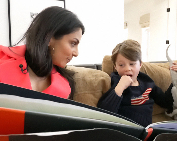 A woman and a young boy with autism sitting on a couch, engaged in an interactive session.