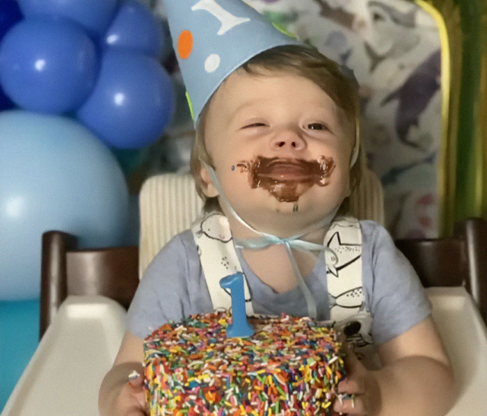 3-year-old celebrating birthday with cake, wearing a party hat, related to autism breakthrough success.