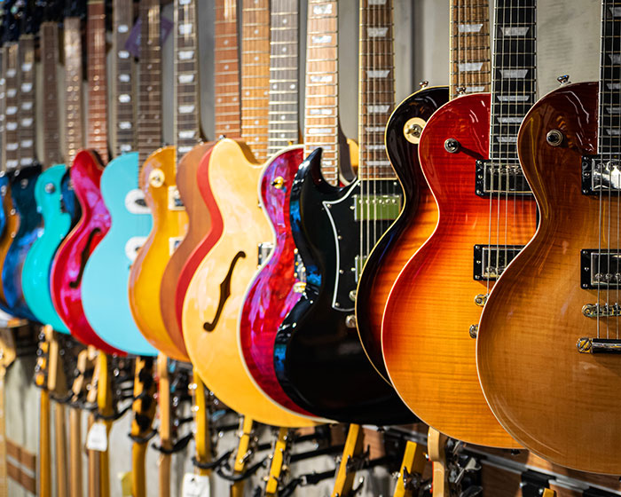 A row of colorful electric guitars on display in a music store.