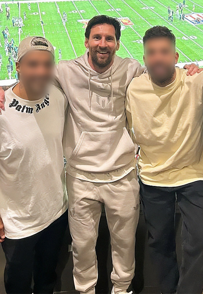 Group of friends at the Super Bowl 2025, wearing casual outfits with a football game in the background.