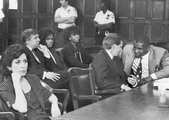 Black and white courtroom scene with individuals seated, related to Mike Tyson's net worth journey.