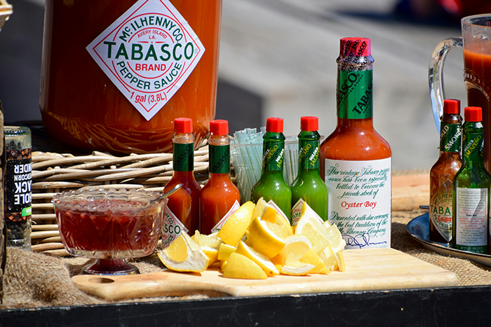 Hot sauce bottles and sliced lemons on a wooden board. Hot sauce bottles and sliced lemons on a wooden board.