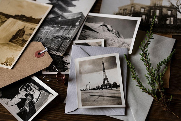 Vintage photos scattered on a table, symbolizing life's biggest regrets collected by older people.