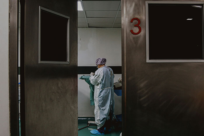 Person in scrubs inside a medical room, symbolizing life regrets of not pursuing a healthcare career.