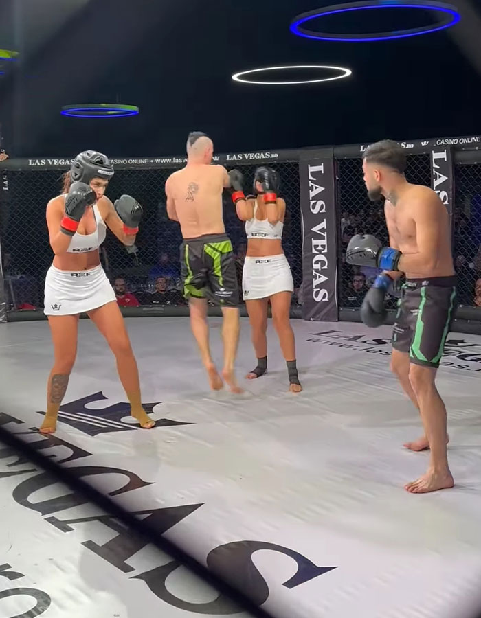 MMA fight scene with two men and three women in a cage, sparking controversy. MMA fight scene with two men and three women in a cage, sparking controversy.