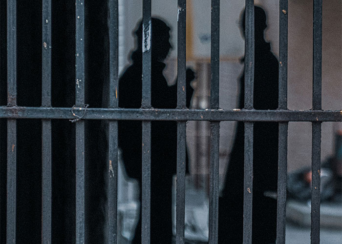 Silhouettes behind bars, suggesting overheard conversations in public places.