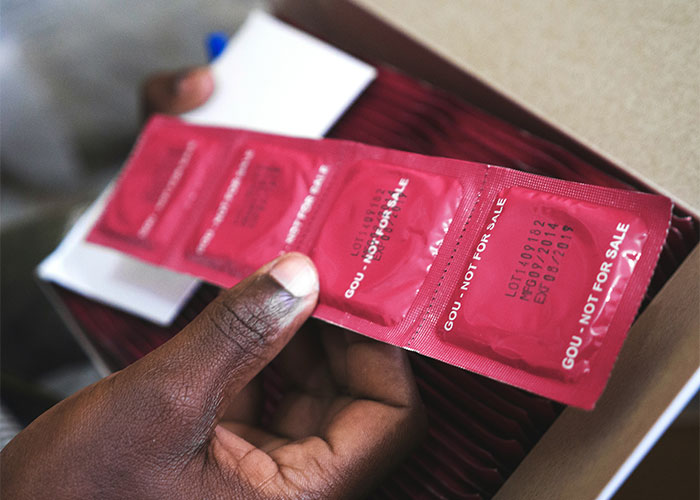 Person holding a strip of red packaged items, each marked "not for sale," related to overheard public discussions.