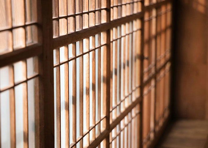 Traditional wooden grid windows with light filtering through, casting shadows.