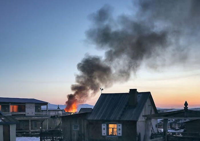 Smoke rises from a house fire at dusk, highlighting intuitive danger detection.