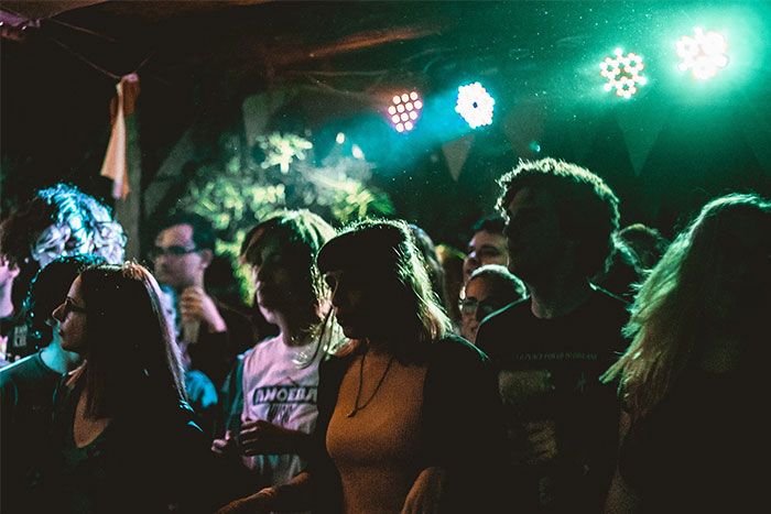 People at a dimly lit concert, showcasing intuition in a crowded setting with vibrant lights.