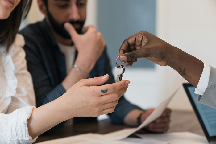 Hands exchanging keys, symbolizing sentimental items people carry despite being useless.