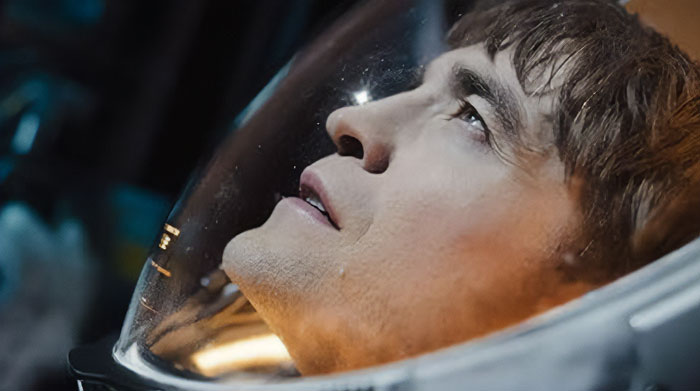 Astronaut from "Mickey 17" looking thoughtful inside a spacecraft, anticipated movies 2025.