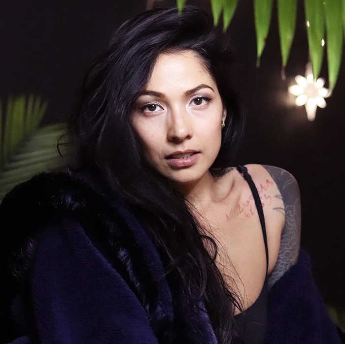 Person in a dimly lit room, wearing a dark fur coat, highlighting BookTube controversy. Person in a dimly lit room, wearing a dark fur coat, highlighting BookTube controversy.