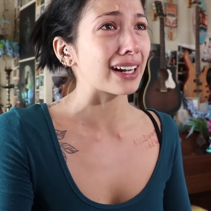 Person emotionally reacting in a room with musical instruments, related to BookTube crisis discussion. Person emotionally reacting in a room with musical instruments, related to BookTube crisis discussion.