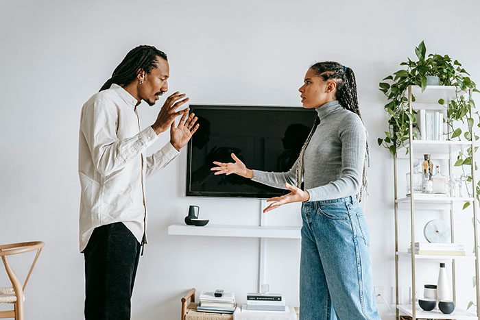 A man and woman having a serious conversation in a modern living room, illustrating parenting challenges with a stepmom. A man and woman having a serious conversation in a modern living room, illustrating parenting challenges with a stepmom.