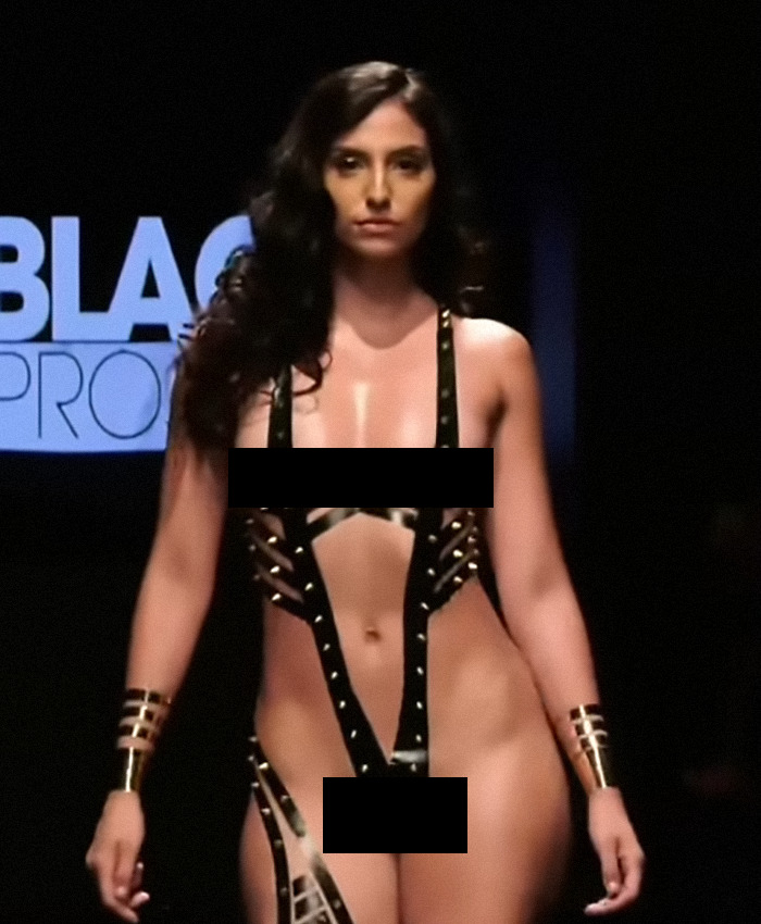Model in New York Fashion Week runway show wearing creative tape outfit.