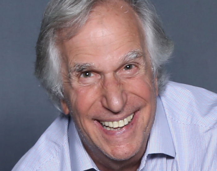 Smiling man in a blue shirt, exemplifying warm celebrity interactions.