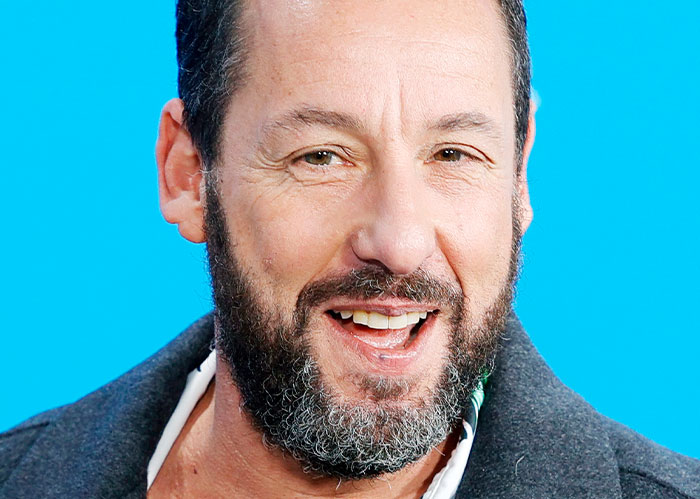 A man with a beard smiling against a blue background, embodying a friendly demeanor similar to Paul Rudd's persona.