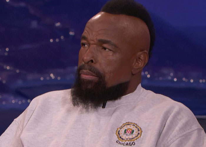 A man with a beard, wearing a Chicago sweater, in a TV studio setting. Paul Rudd not shown.