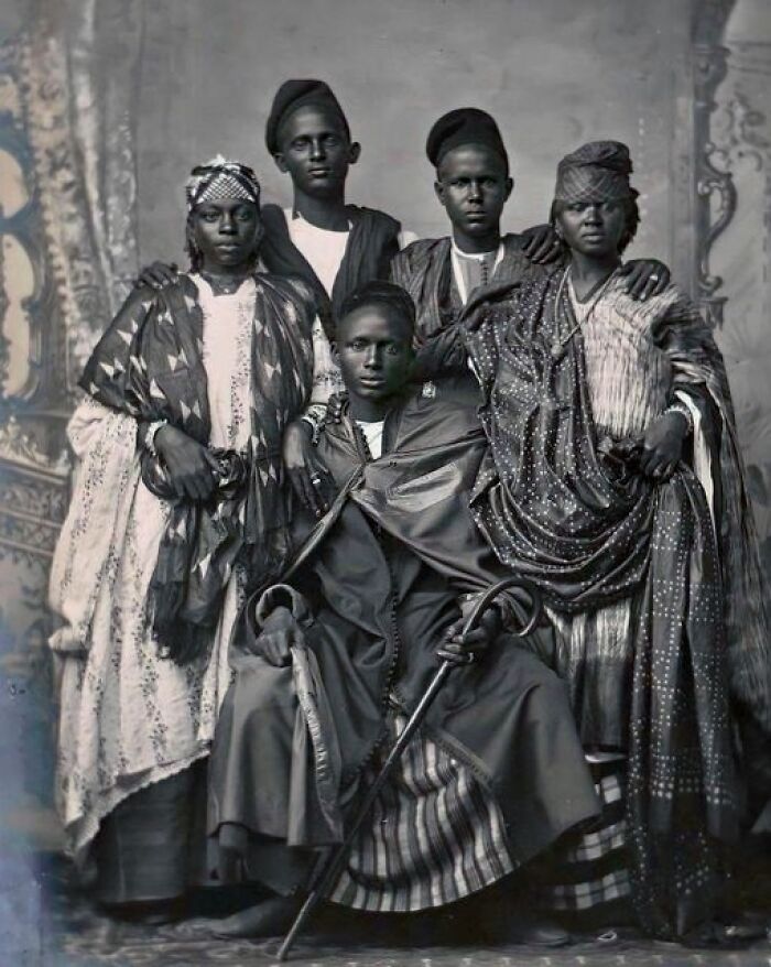Historical photo from over a hundred years ago showing five individuals in traditional attire.