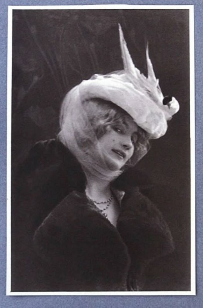 Vintage photo of a woman in an elegant hat and fur coat, showcasing timeless fashion from more than a hundred years ago.