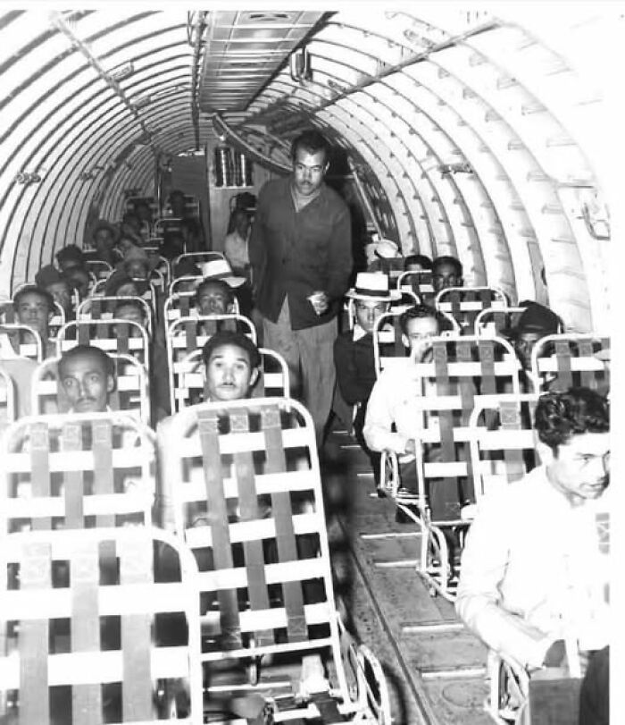 Passengers seated in a vintage airplane illustrating historical moments that resonate today.