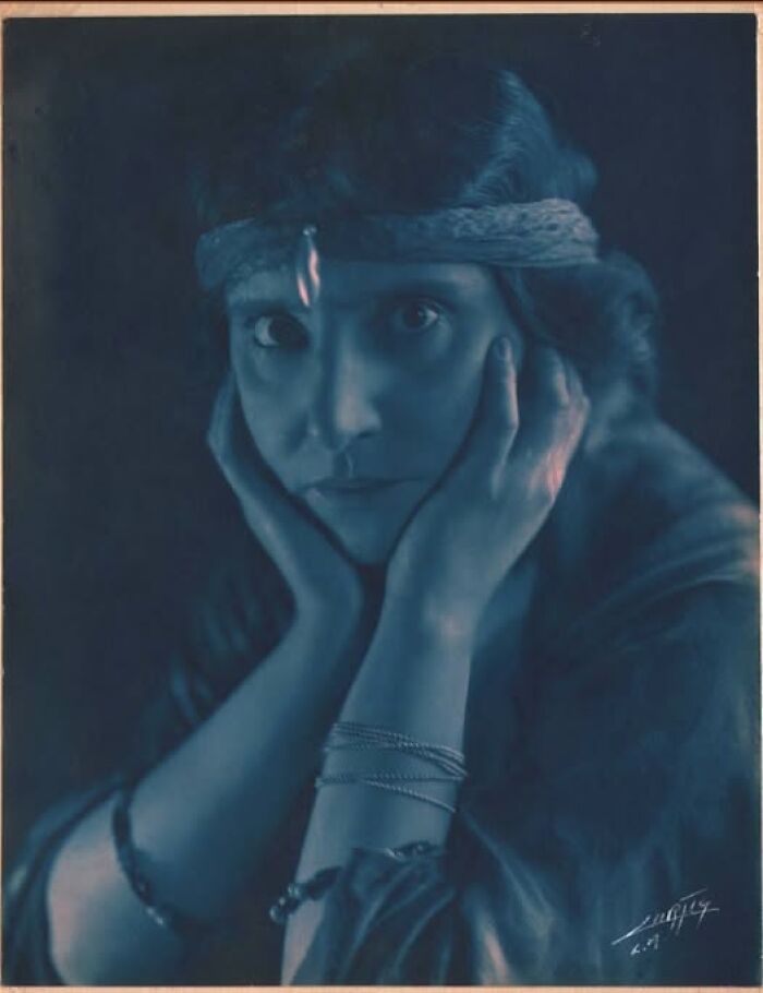 Vintage portrait from over a hundred years ago, featuring a woman with a headband, looking thoughtfully at the camera.