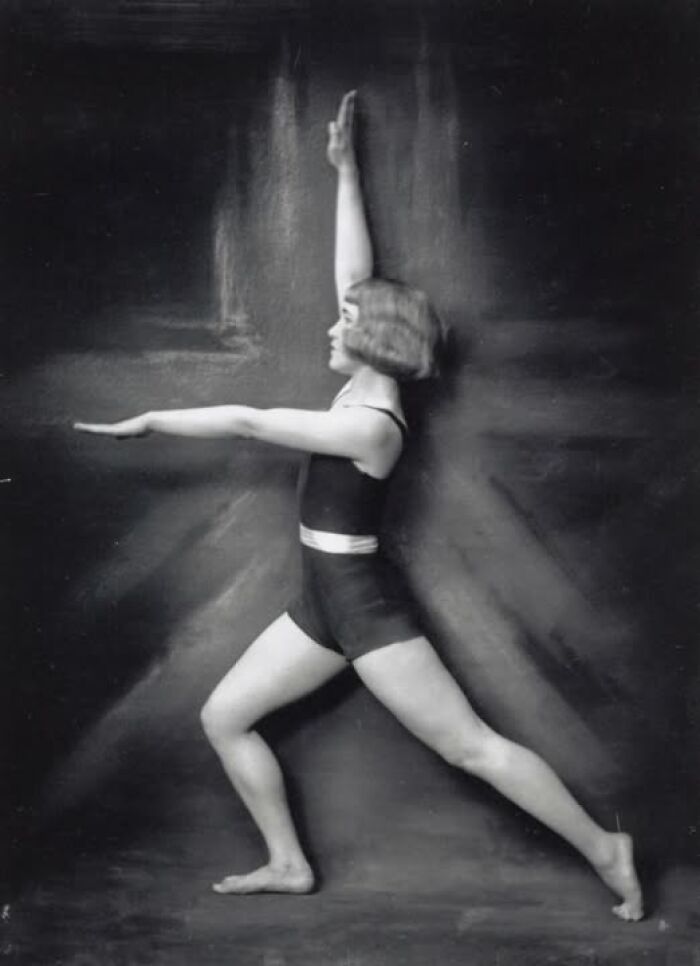 Vintage photo of a woman in a poised yoga stance, showcasing timeless elegance over a hundred years ago.