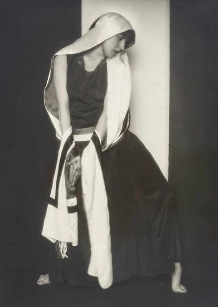 Historical photo of a woman draped in fabric, striking a pose from more than a hundred years ago.