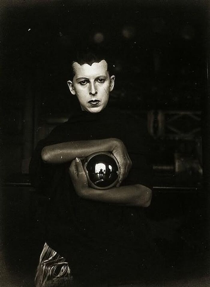 Historic portrait of a person from over a hundred years ago holding a reflective orb, evoking timeless resonance.