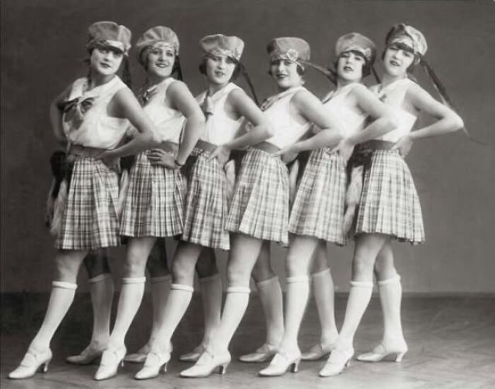 Vintage photo of six women in dance costumes from over a hundred years ago, showcasing historical fashion styles.