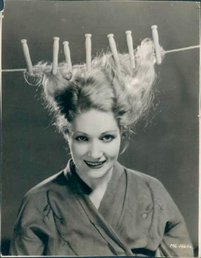 Vintage photo of a woman with hair pinned up humorously, capturing fashion from a hundred years ago.