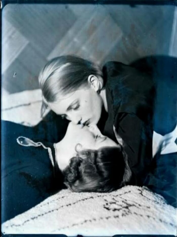 Vintage photo of two women from more than a hundred years ago sharing a kiss, showcasing timeless emotion.