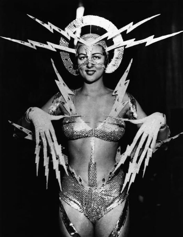 Vintage photo of a woman in a lightning-themed costume, showcasing historical fashion that continues to resonate today.