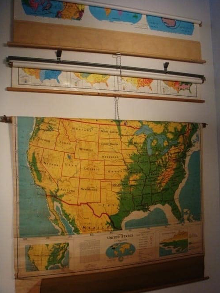 Old-school items memories of vintage pull-down classroom maps hanging on a wall.