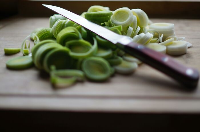 Sliced leeks on a cutting board with a knife, showcasing overlooked ingredients.