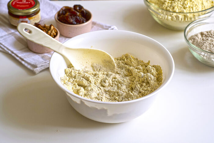 Mixing bowl with flour, dates, and nuts as overlooked ingredients on a kitchen counter.