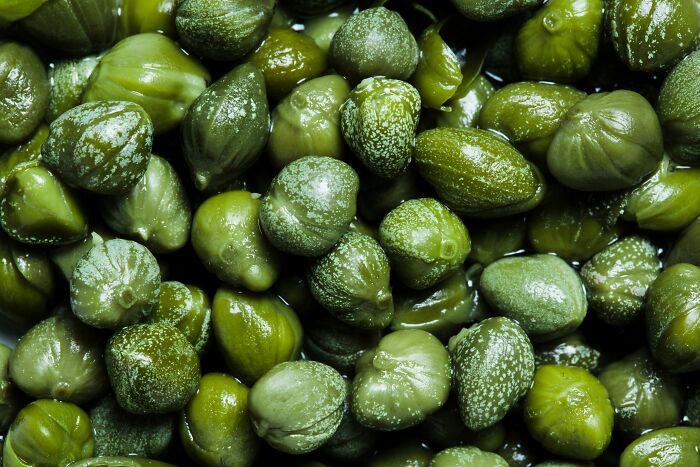 Close-up of capers, one of 59 amazing overlooked ingredients, showcasing their green color and texture.