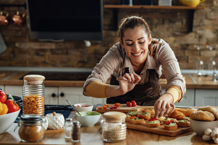 Woman preparing fresh homemade food in a cozy kitchen setting.