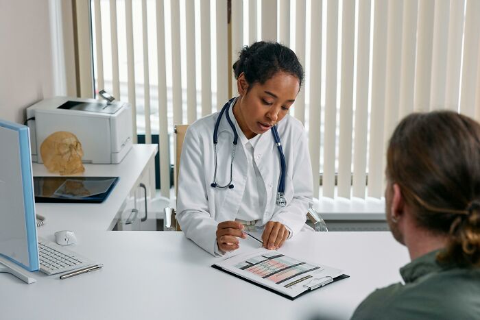 Doctor consulting a patient, possibly discussing reasons to quit fast food for improved health.