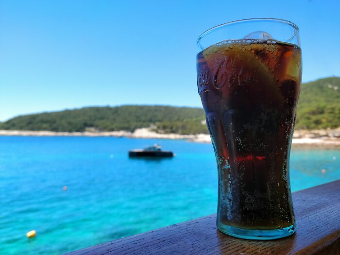A glass of soda by the sea, symbolizing fast food lifestyle choices.