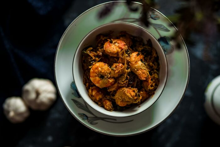 Bowl of homemade shrimp stir-fry on a dark table, illustrating a healthier alternative to fast food.