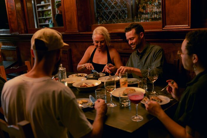 A group dining in a cozy restaurant, sharing reasons to quit fast food and savoring a meal together.