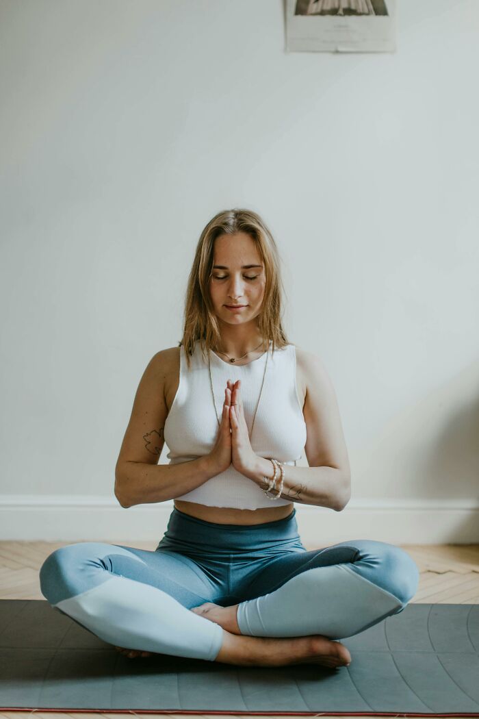 Woman meditating cross-legged in a calm setting, improving her life through mindfulness practices.