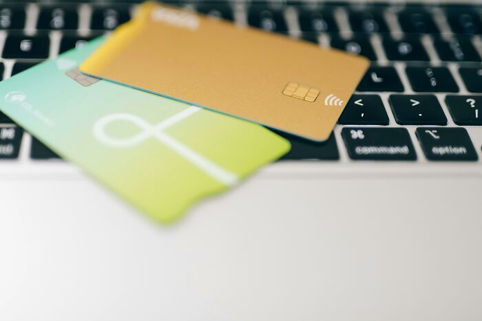 Credit cards on a laptop keyboard, representing ways to improve lives through technology and finance.