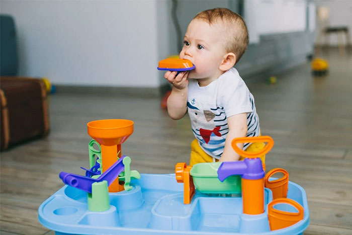 Child playing with toy set on floor, illustrating the concept of petty grudges.