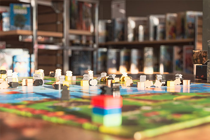 Board game setup indoors, capturing a colorful array of pieces, reflecting themes of petty grudges and strategy.