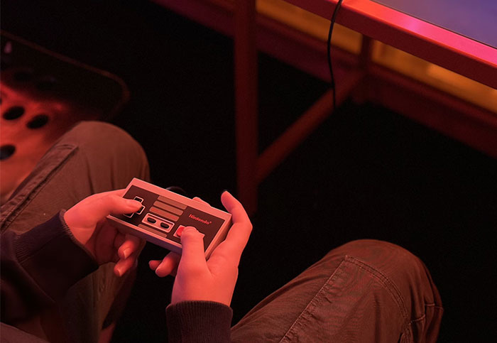 Hands holding a retro Nintendo controller, possibly linked to nostalgic grudge stories.