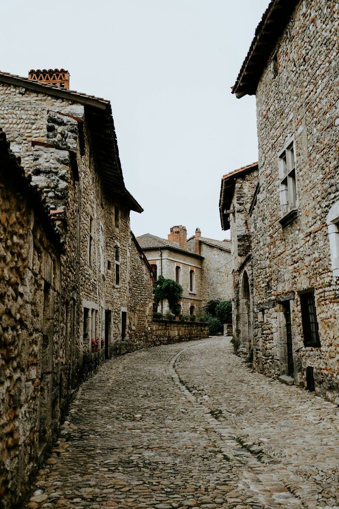 Cobblestone street between rustic stone buildings, illustrating culture shocks experienced abroad.