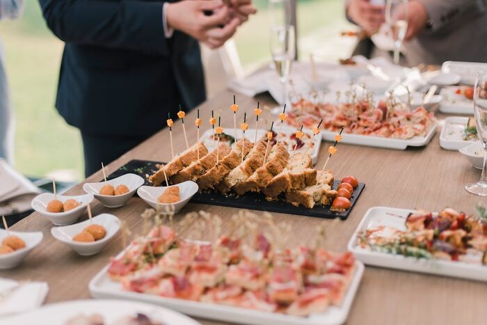 Wedding guests dislike sparse food selections at receptions, showing appetizers on a table setting.